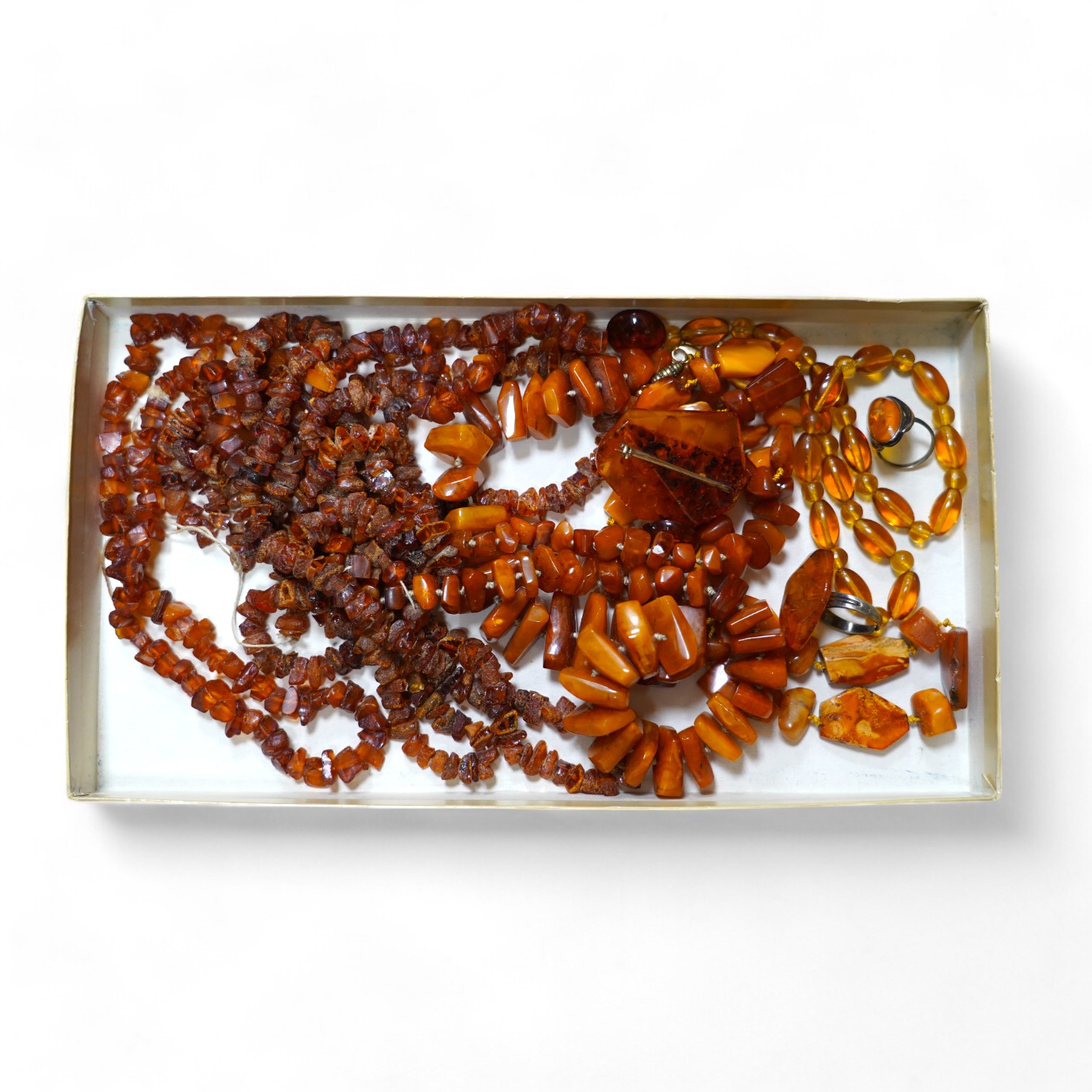 Five assorted single strand amber necklaces, including jagged pebble and unpolished, longest 176cm, together with two mounted amber rings, a pair of ear clips and a brooch, gross weight 357 grams. Condition - poor to fai